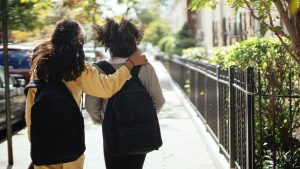 Two girls walking and hugging